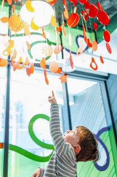 Child looking up at baby mobile