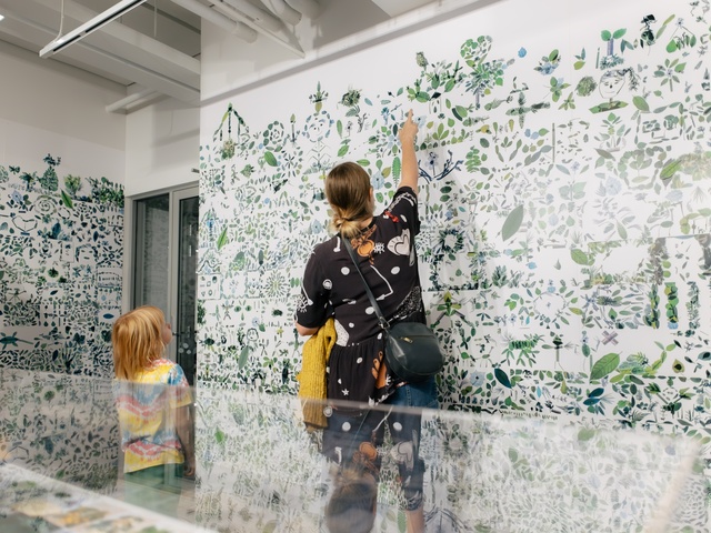 Image of two people from behind, viewing the exhibition